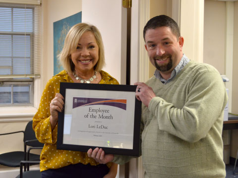 Lori LeDuc and Keith Gelhausen holding award plaque.