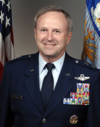 Mark Pillar standing in front of flags