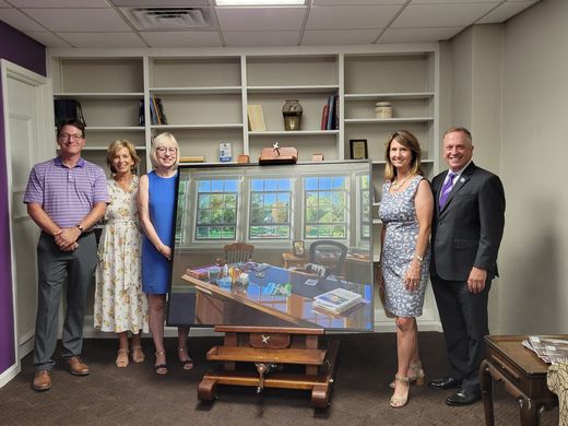 people standing by a painting.