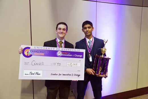 Students holding their trophy and check