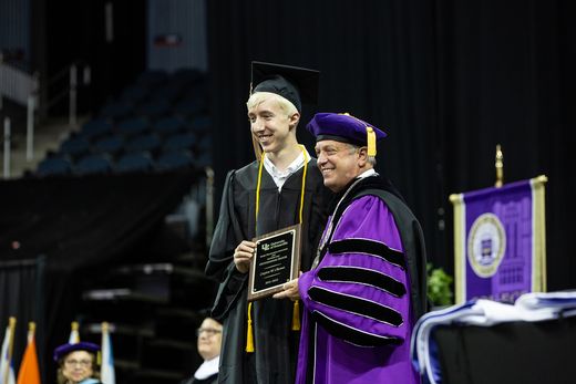 Crayton poses with Prez P at graduation