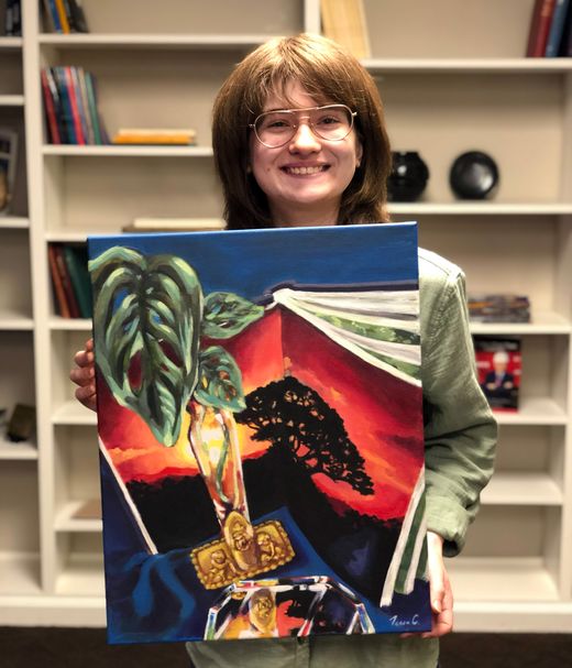 Student holding a painting